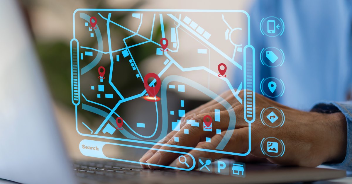 A person places their hand on a laptop keyboard. A map with tracking data and a bar underneath that says "Search' is visible.